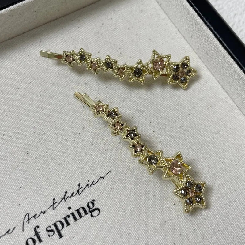 Gold alloy hair barrette with rhinestones and a star charm, shown as a side clip for bangs.