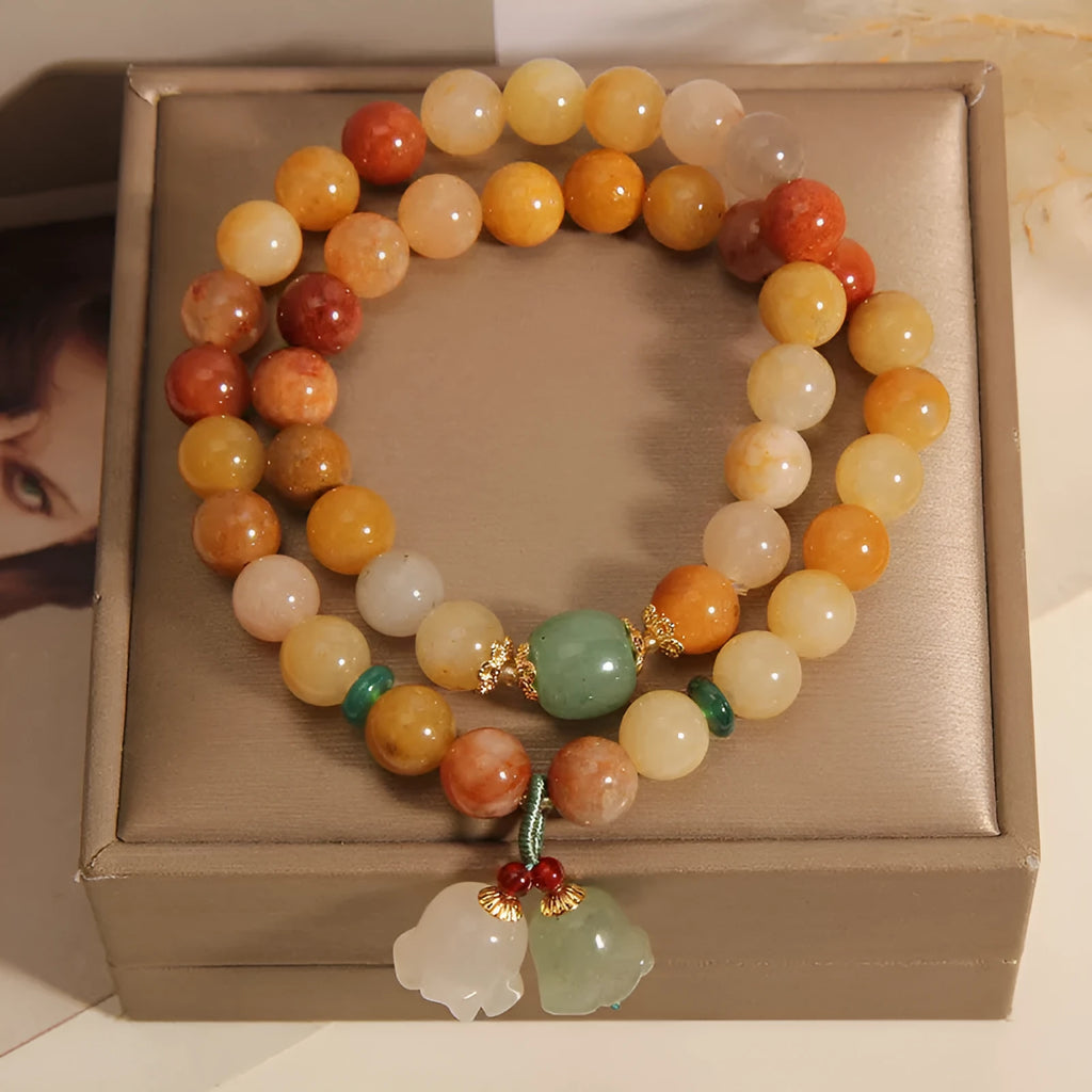 Natural green jinsi jade multi-layer bracelet for women with an orchid pendant charm on an elastic band.