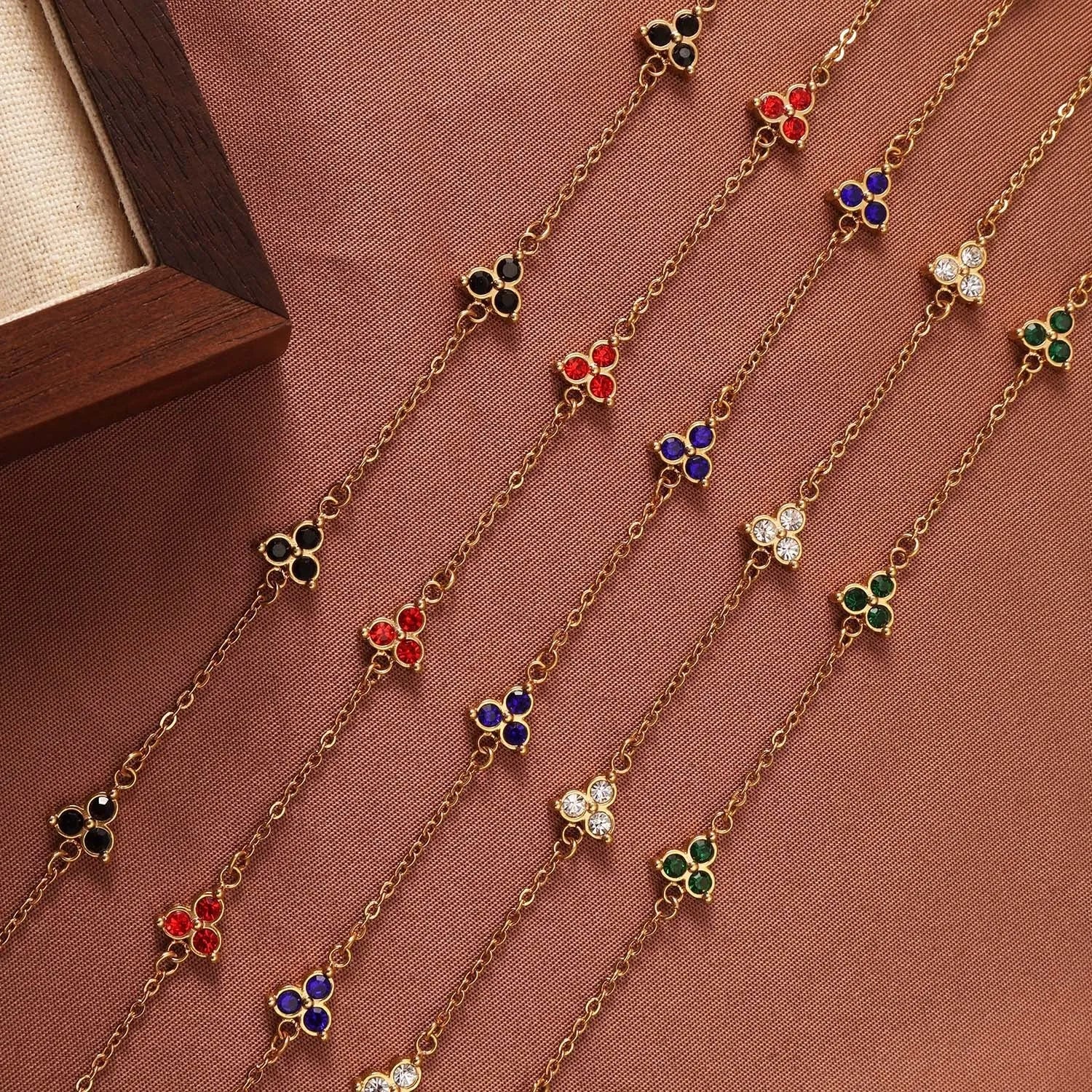 Women's stainless steel bracelet with three triangular charms set with coloured zircon stones.