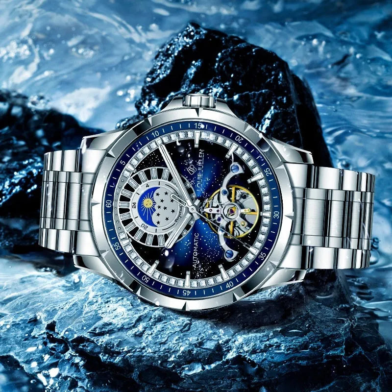 Silver automatic mechanical watch with blue dial on stainless steel bracelet showing transparent caseback