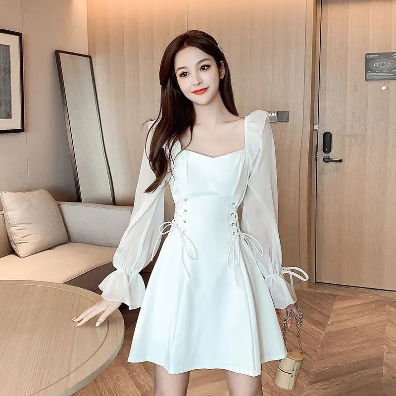 White women's chiffon dress with patchwork detail, long sleeves, and a waist-slimming long skirt.