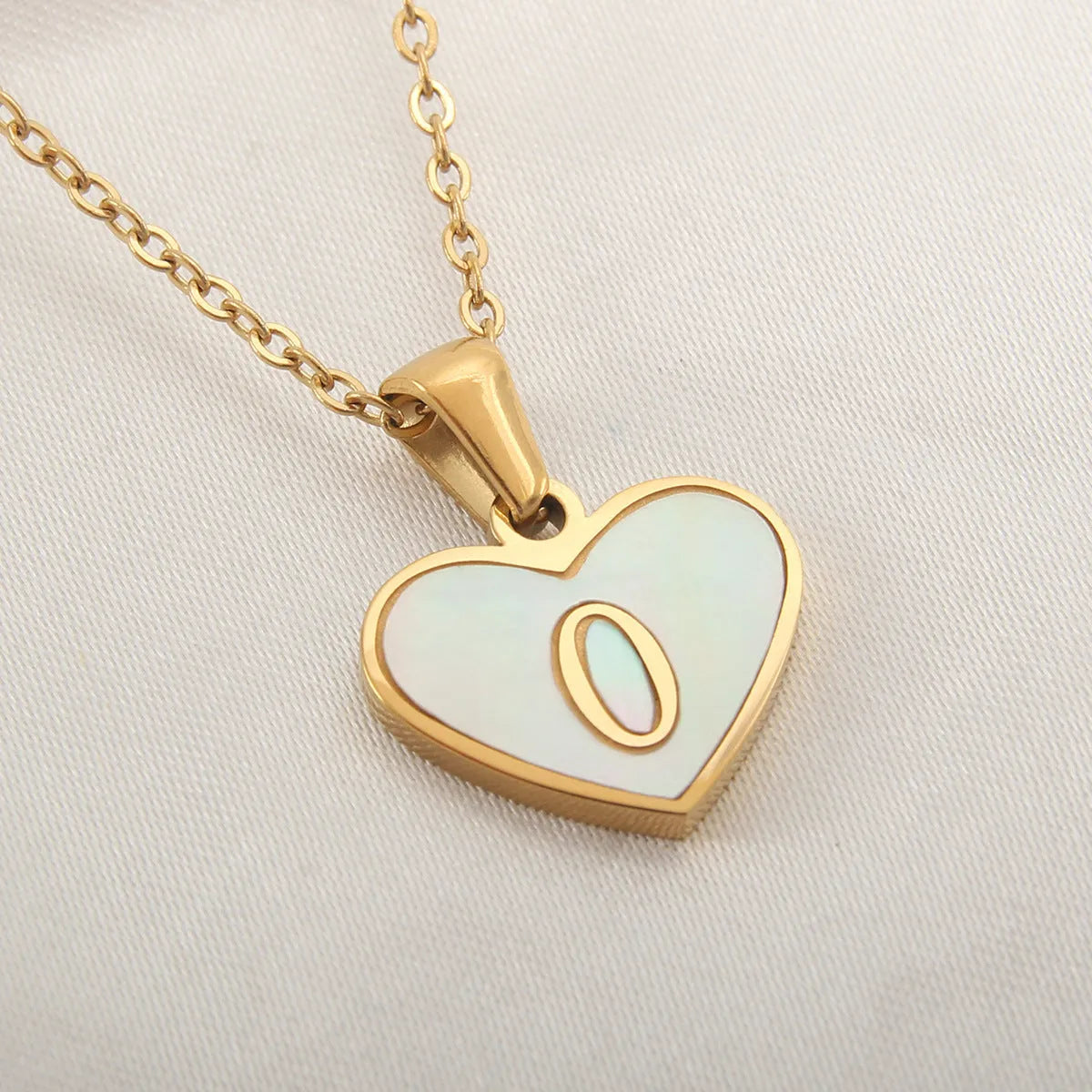 Gold plated heart-shaped white shell pendant personalised initial necklace on a stainless steel chain.