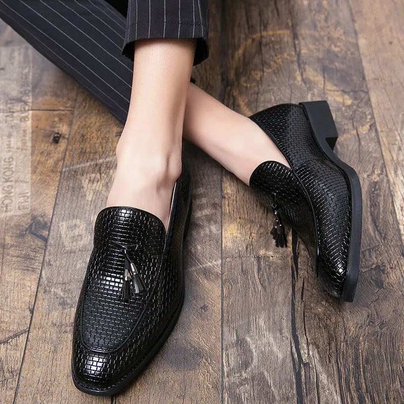 Men's black pointed toe slip-on shoes with a tassel detail on the vamp