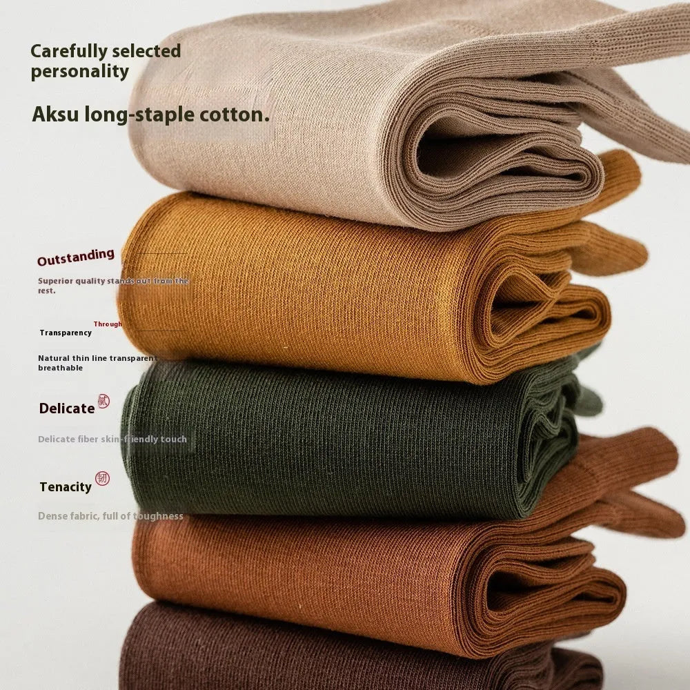 Mid-calf men's socks in solid colours made from combed cotton, shown in a stack.