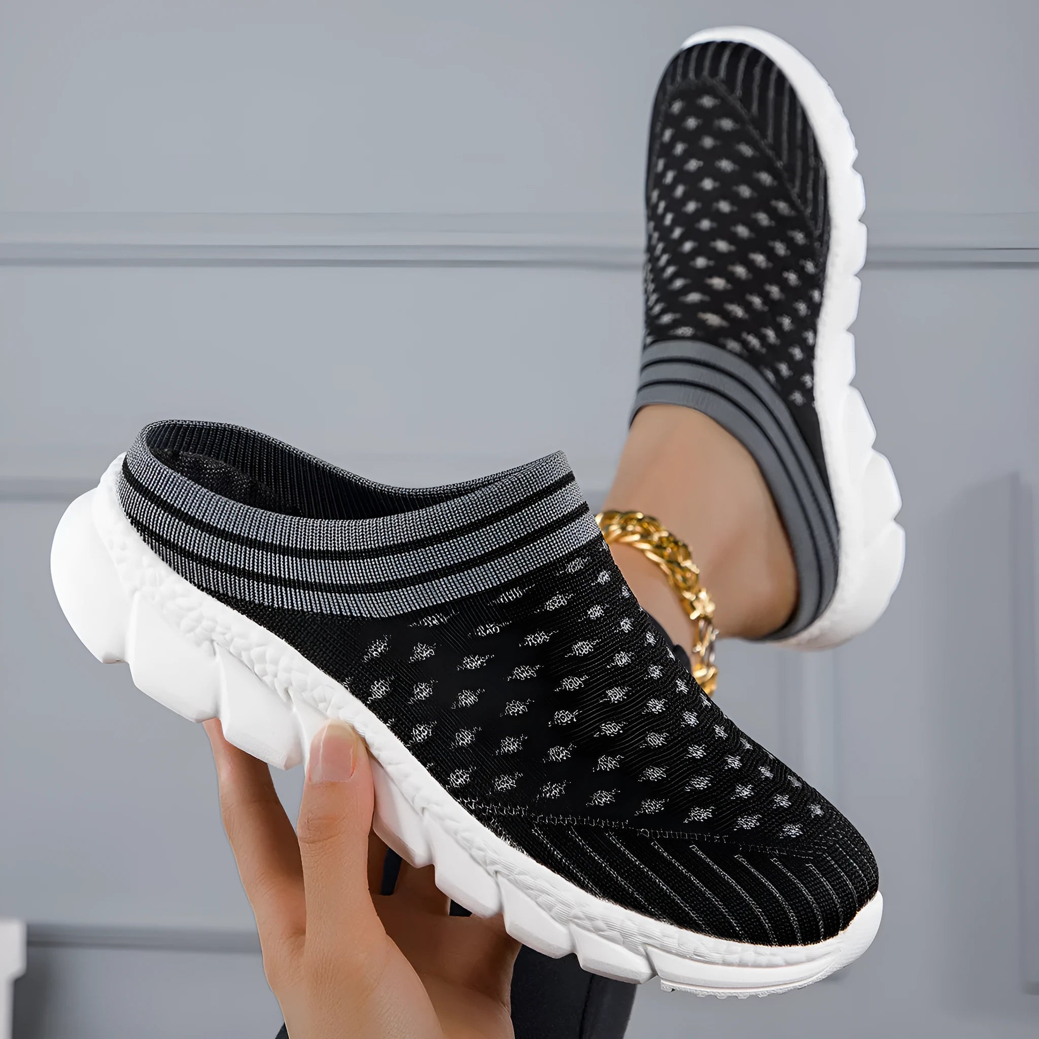 Women's black Flyknit slipper shoes with striped pattern and hollowed-out design on a lightweight viscose sole.