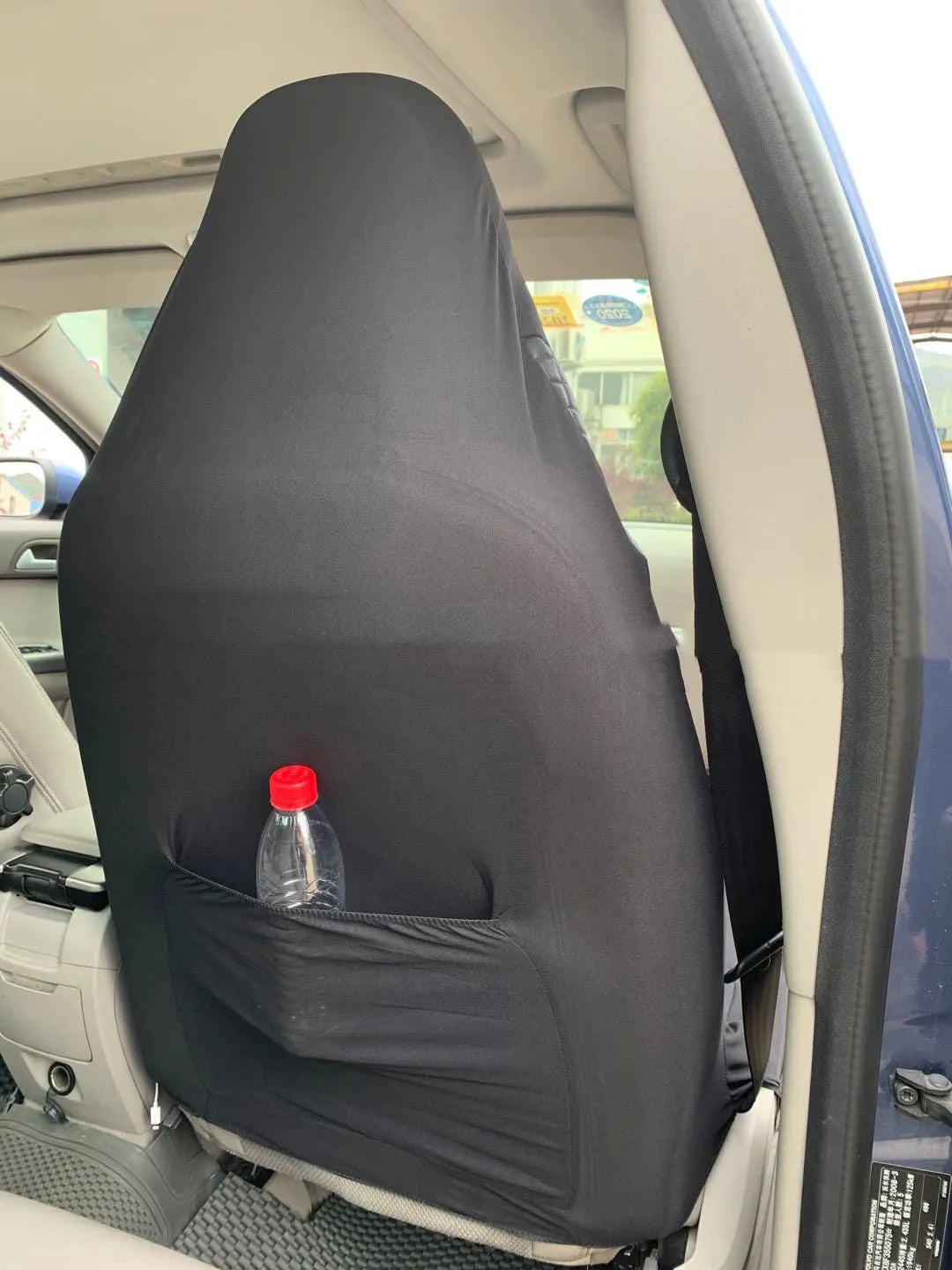 Black quilted automotive seat cover made from PU and polyester fabric, shown with plastic attachment hooks.