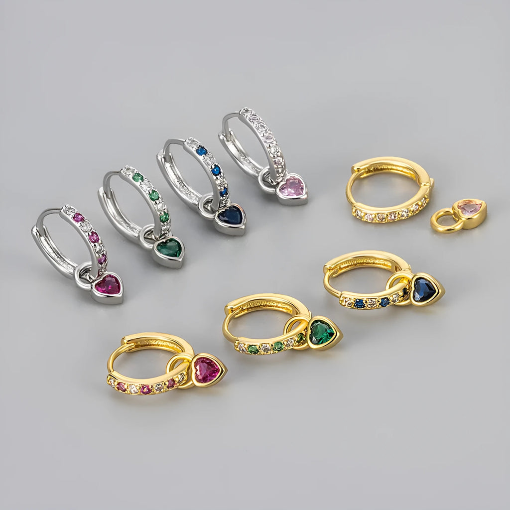 A pair of women's heart-shaped clip earrings with a coloured gemstone centre, available in gold or white gold colour metal.
