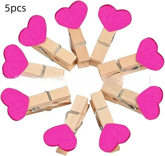 Five small solid wood heart-shaped clips in different colours showing handmade craft details
