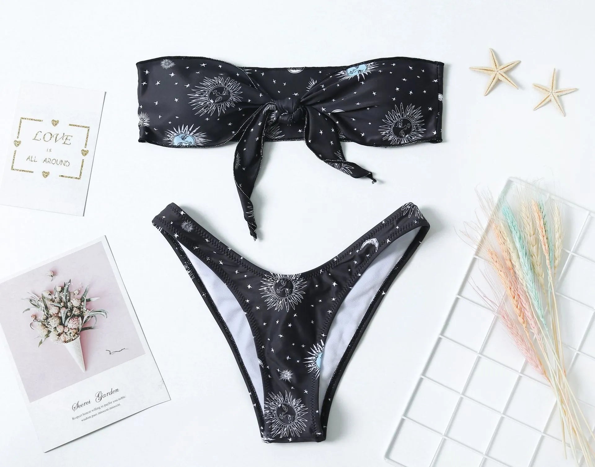 Black one-piece swimsuit with bikini print, split tube top, and backless design for women.