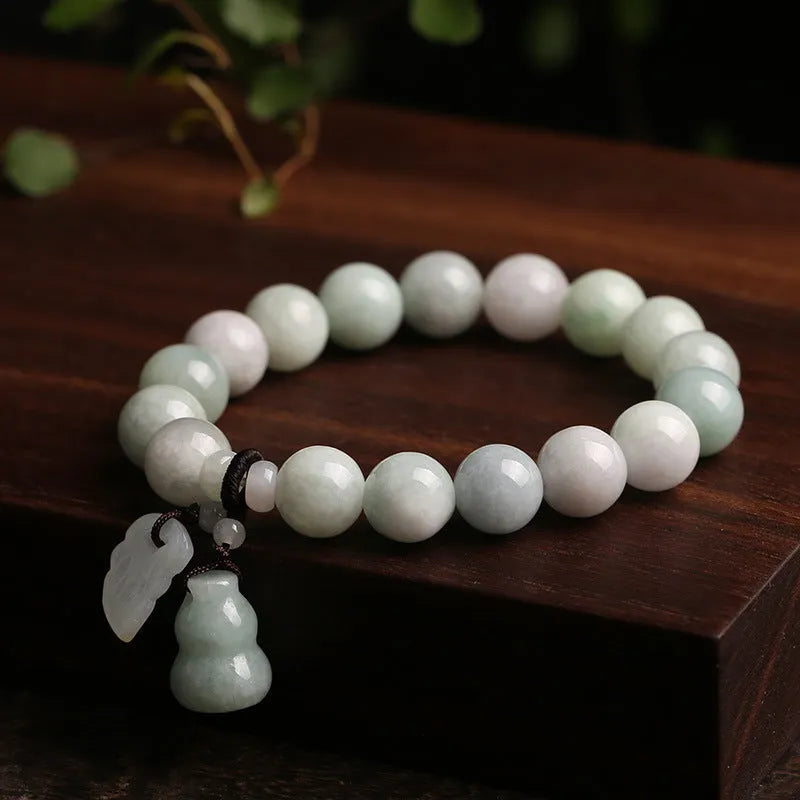 Natural green jade bracelet with hanging geometric charms including an Apple and a Maitreya Buddha pendant.