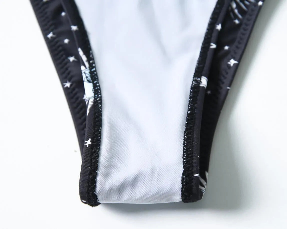 Black one-piece swimsuit with bikini print, split tube top, and backless design for women.