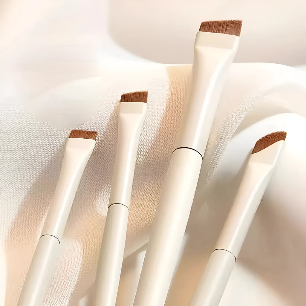 Four angled eyeliner and brow brushes with fine tips in leather case for precise makeup application