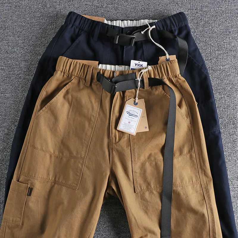 Men's khaki cotton work trousers with N I buckle belt showing three-dimensional cutting and mid waist design