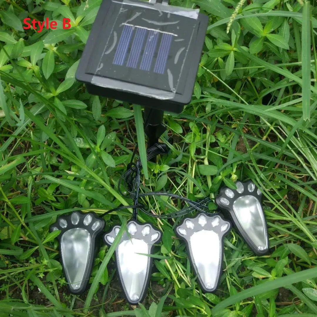 Black solar powered animal paw print LED garden lights set of four with solar panel pole