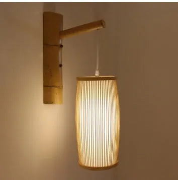 Small woven bamboo table lamp with a natural finish, shown on a wooden surface.
