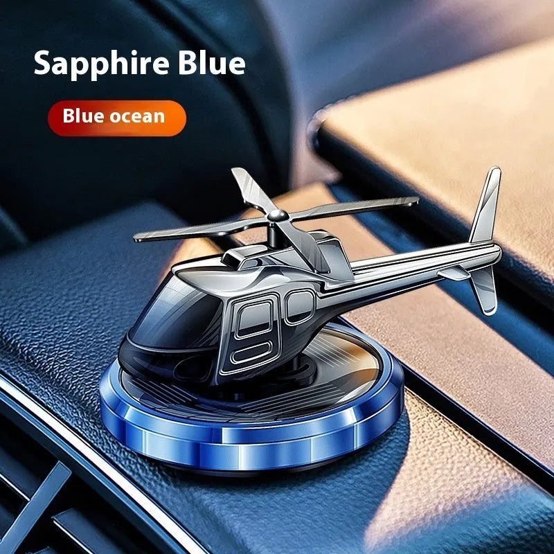 Silver metal helicopter car air freshener with rotating blades on dashboard