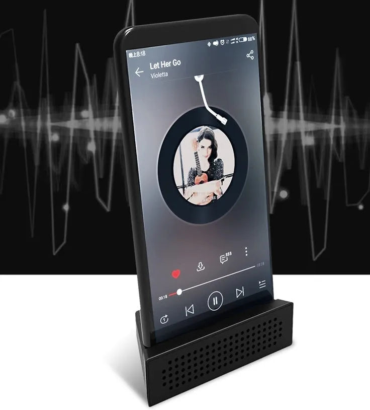 Portable Apple-compatible phone amplifier bracket in multiple colours on desktop
