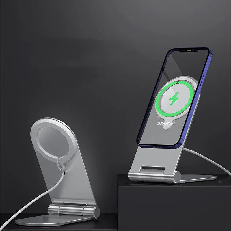 Silver vertical adjustable magnetic phone bracket for iPhone 12 on a table.