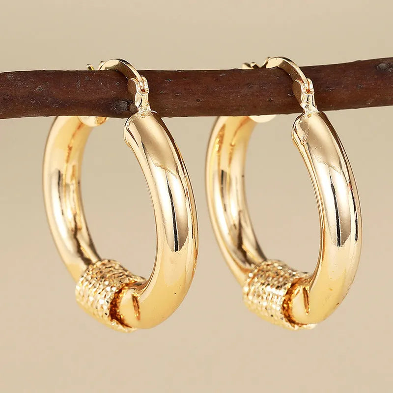 Geometric copper earrings with ring and line design in golden colour on ear