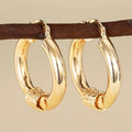 Geometric copper earrings with ring and line design in golden colour on ear