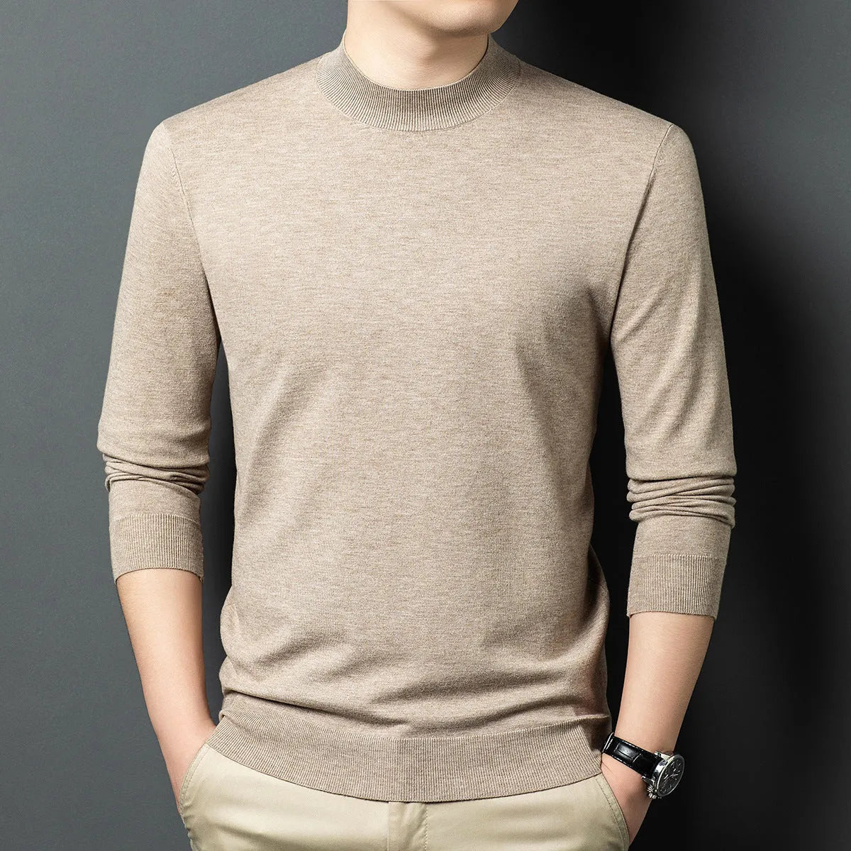 Man wearing a round neck grey wool blend sweater with long sleeves.