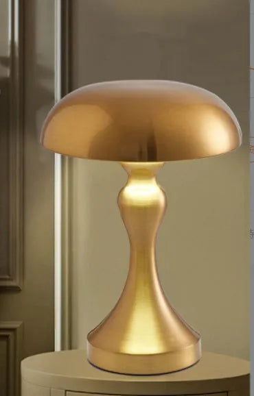 Metallic rechargeable touch desk lamp showing bronze, gold, and silver colour options on a wooden desk.