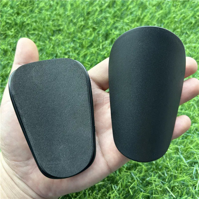 Extra small mini football shin guards in black and white colours measuring 8x5cm