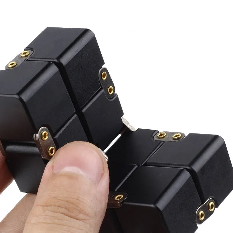 Silver zinc alloy infinity cube fidget toy with rotating segments shown on a flat surface