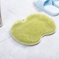 Orange silicone bath massage brush mat with suction cups on a bathroom floor