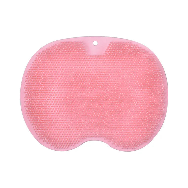 Orange silicone bath massage brush mat with suction cups on a bathroom floor
