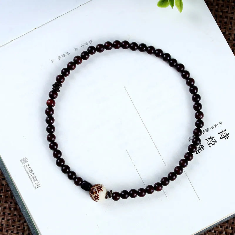 Rosewood bracelet with floral bead and knitted construction showing natural wood texture
