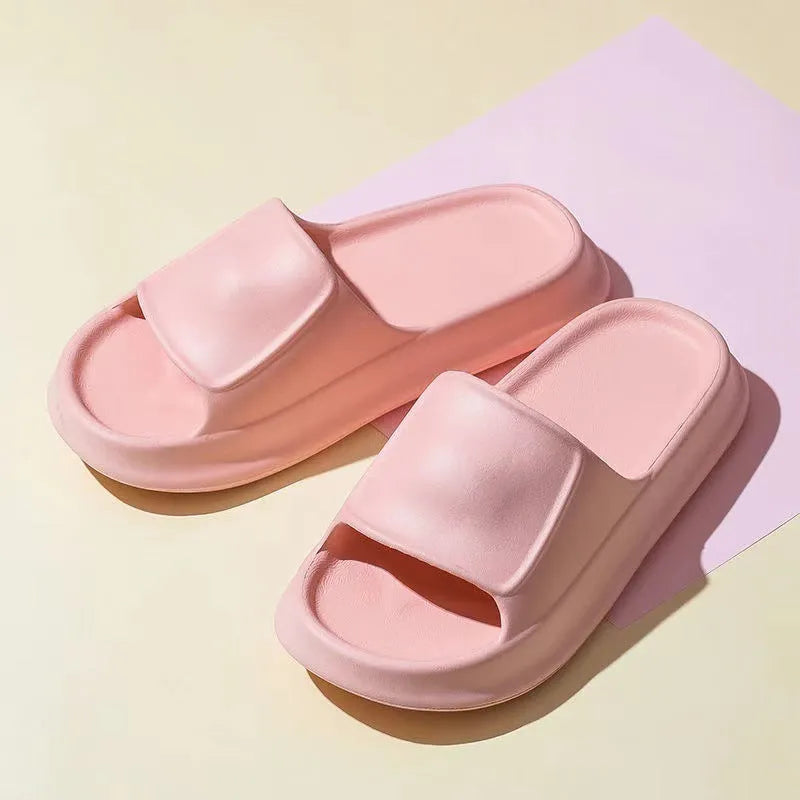 Thick-soled EVA flip-flop slippers in multiple colours on a bathroom floor, showing non-slip sole texture.