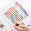 Muji 12-piece gel pen set with 0.5mm fine nibs showing blue ink demonstration