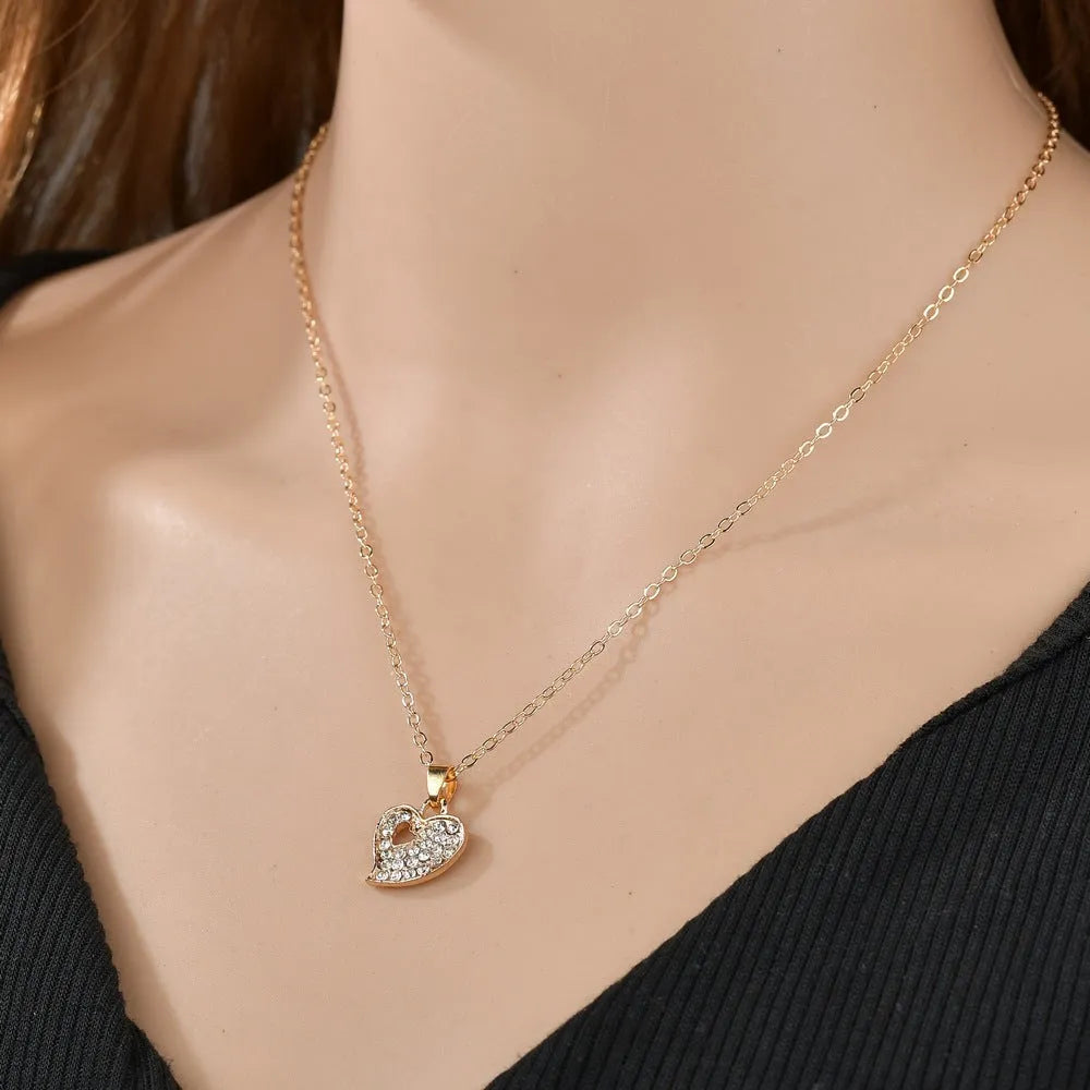 Gold jewellery set with earrings, pendant and adjustable bracelet showing love, water drop and bell motifs