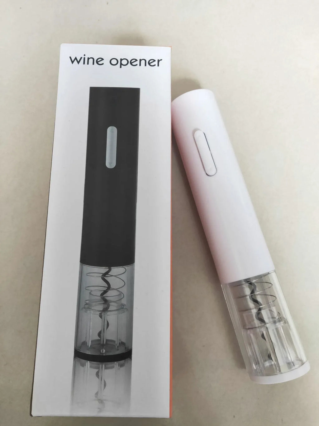 Black, red, and white electric wine bottle opener with foil cutter on a kitchen counter