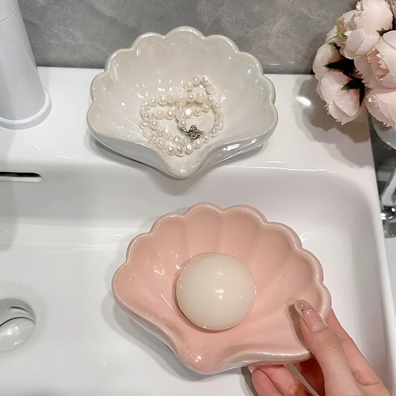 White or pink plastic shell-shaped soap dish for bathroom sink storage