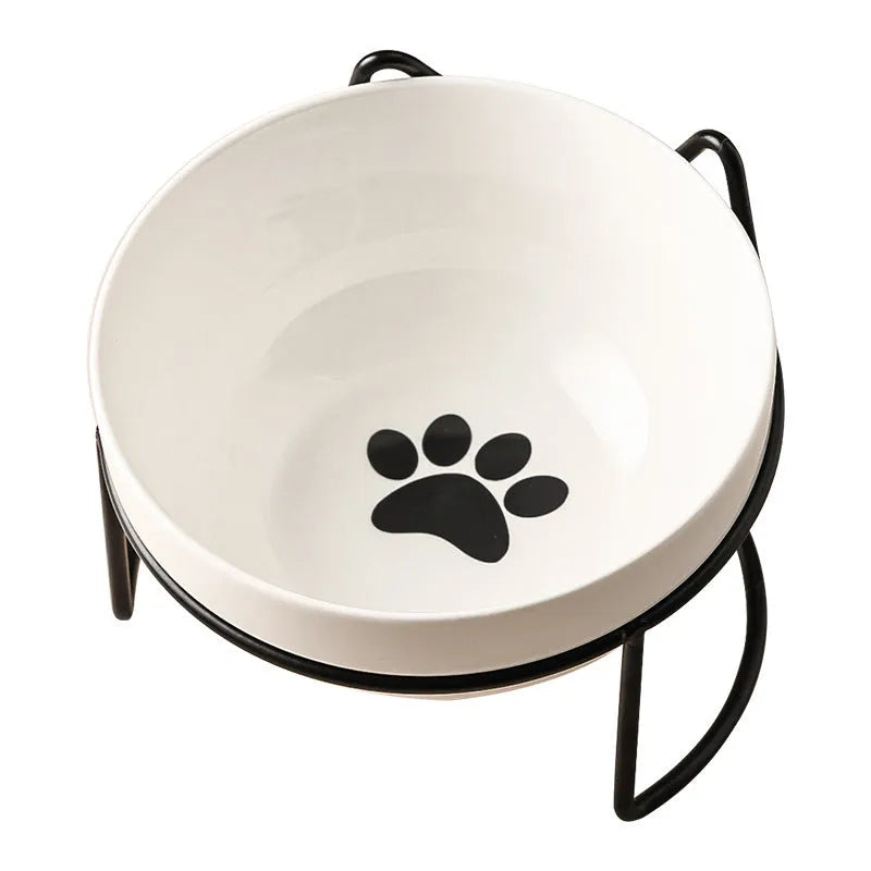 White ceramic pet bowl with cat paw design on a black metal stand with cat ear details.