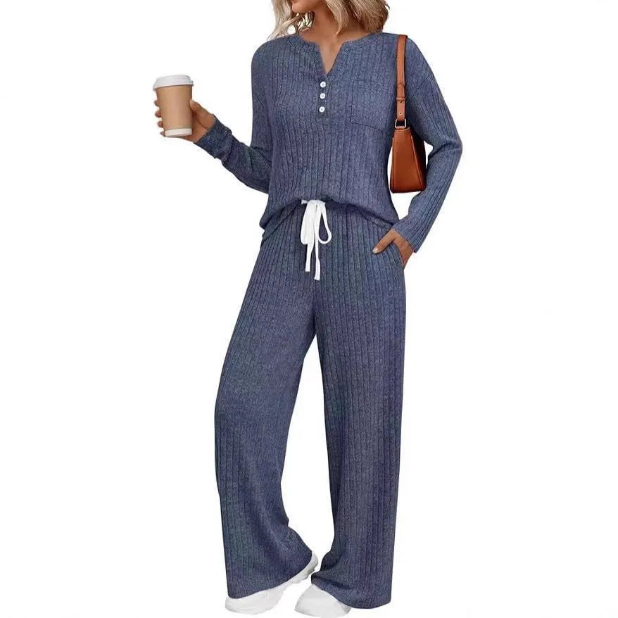 A person wearing a striped V-neck knit long coat with lace-up details and pockets, paired with matching pants.