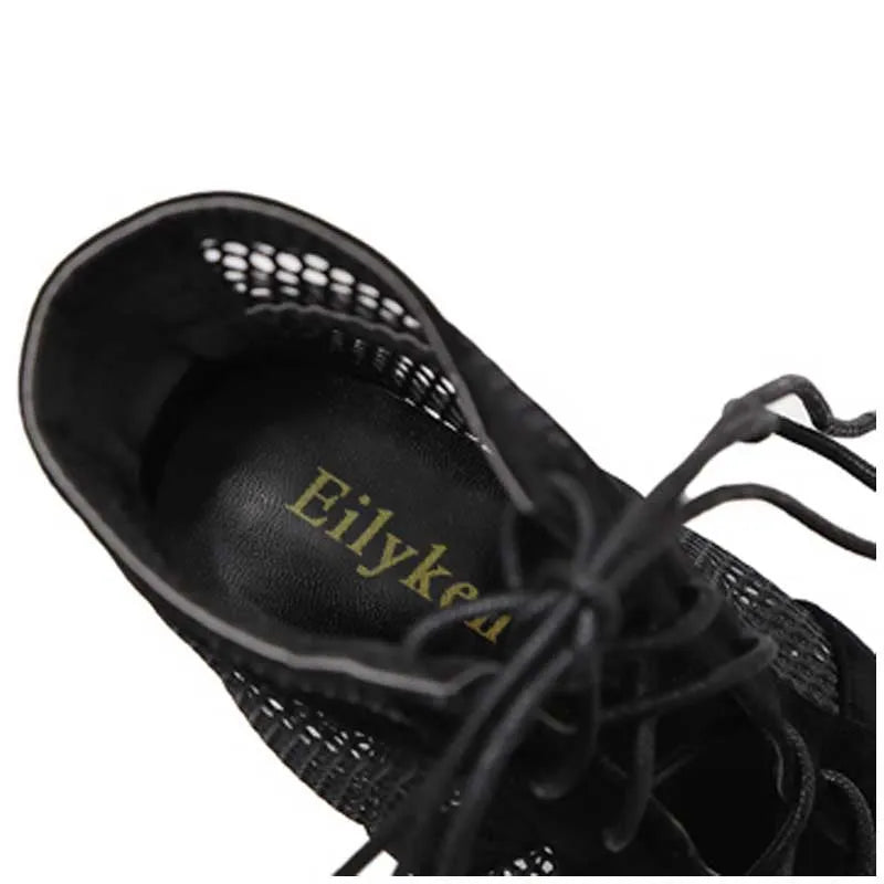 Black suede lace-up high heel women's shoes with 11.5cm heel on wooden surface