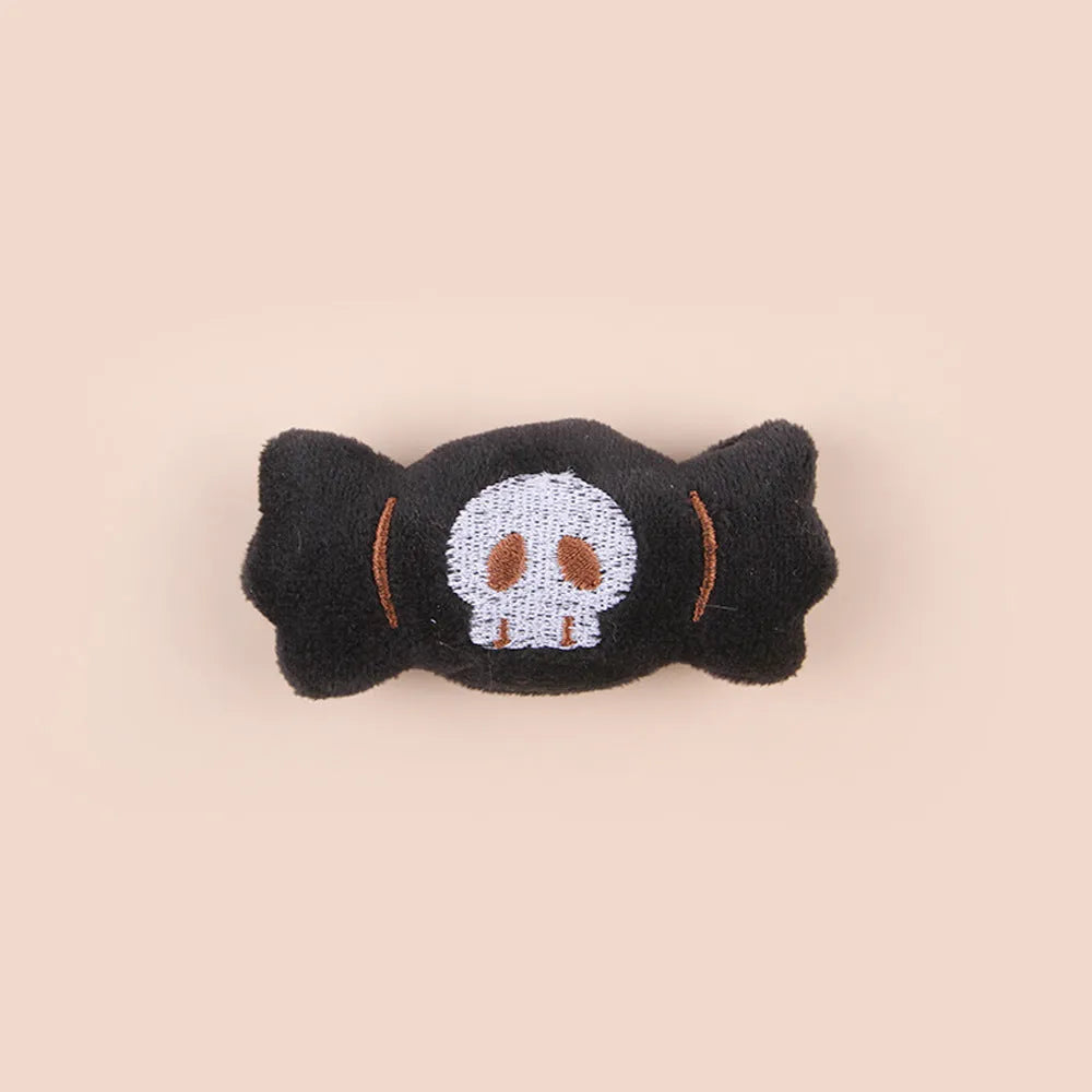 Small plush cat teaser toy with candy, eyes and skull attachments on lightweight handle