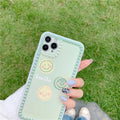 Green TPU iPhone case with geometric smiley face and polka dot frame design on a table.