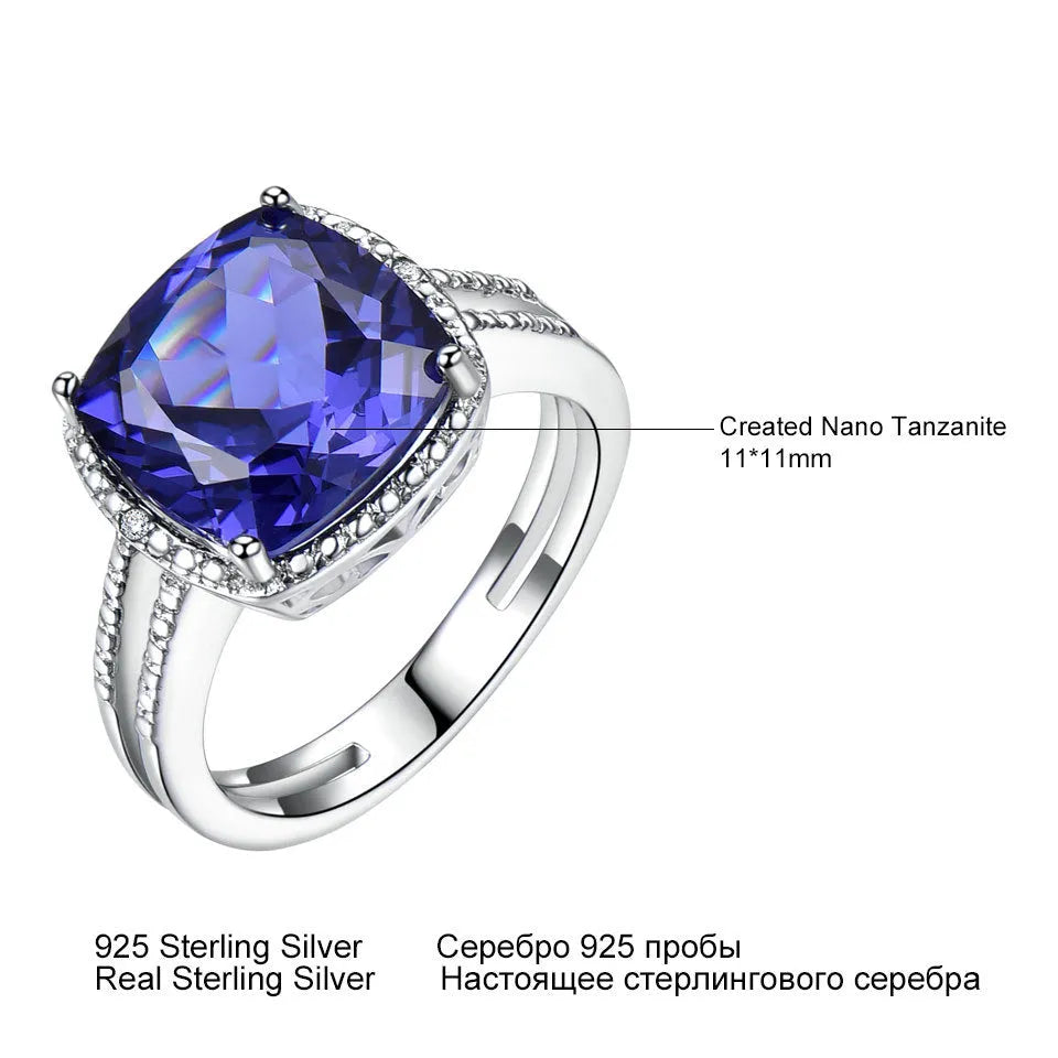 Women's sterling silver ring with oval blue Tanzanite gemstone on a finger.