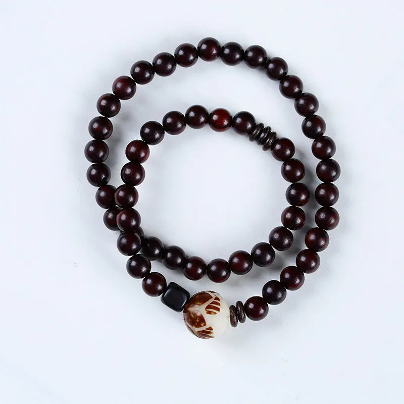 Rosewood bracelet with floral bead and knitted construction showing natural wood texture