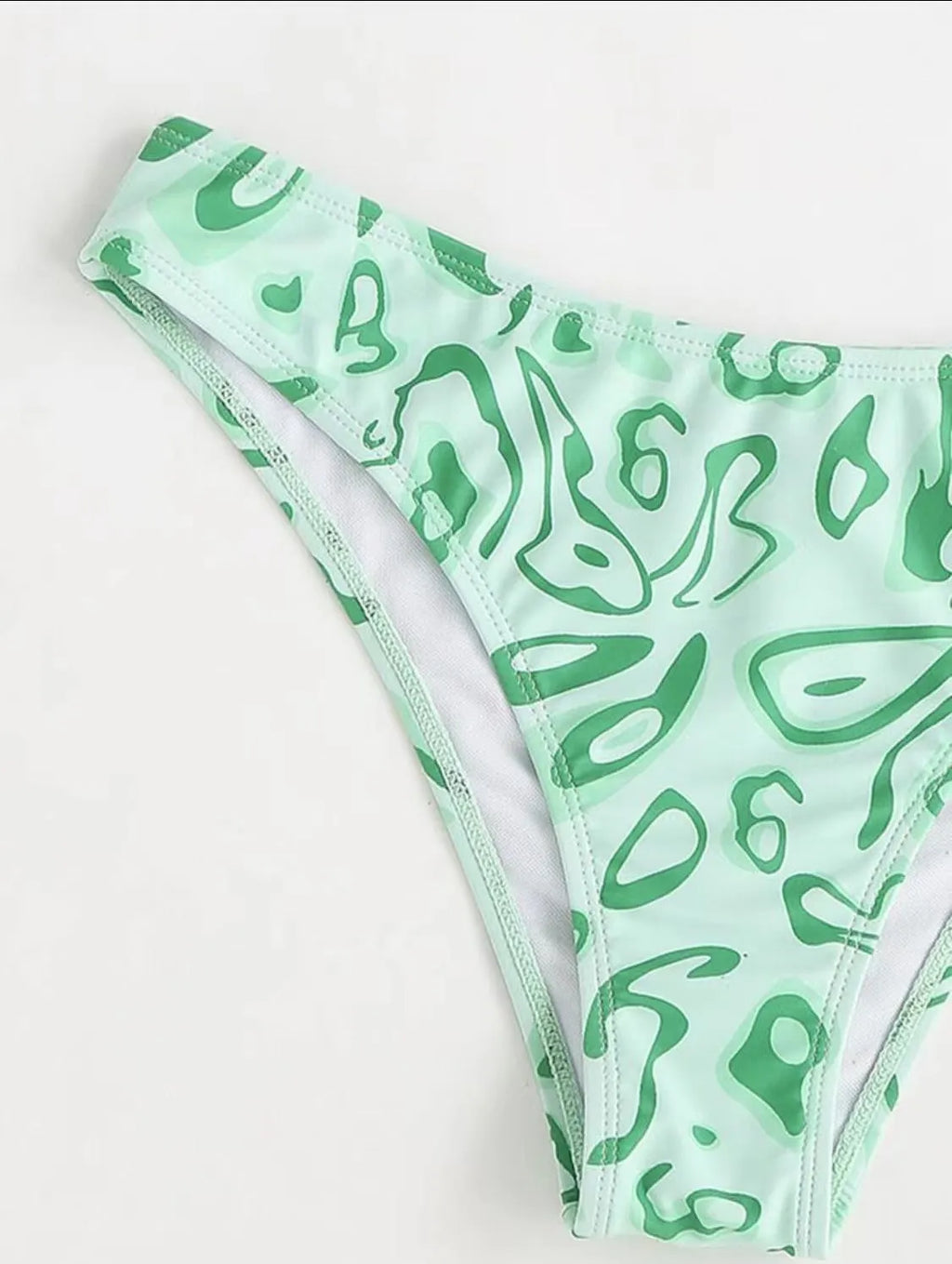 Green floral bandeau bikini swimsuit with split design on a mannequin