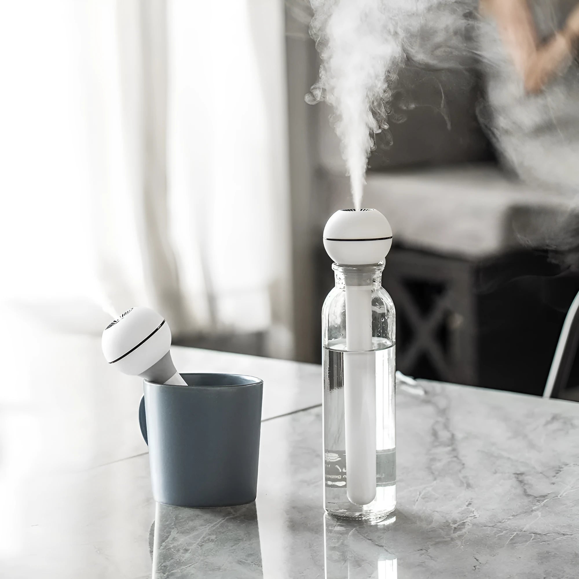 Pink and white Magic Wand portable USB humidifier with columnar design on a table.