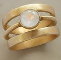 Gold-plated geometric titanium steel ring with micro-inlaid white chalcedony detail shown on finger