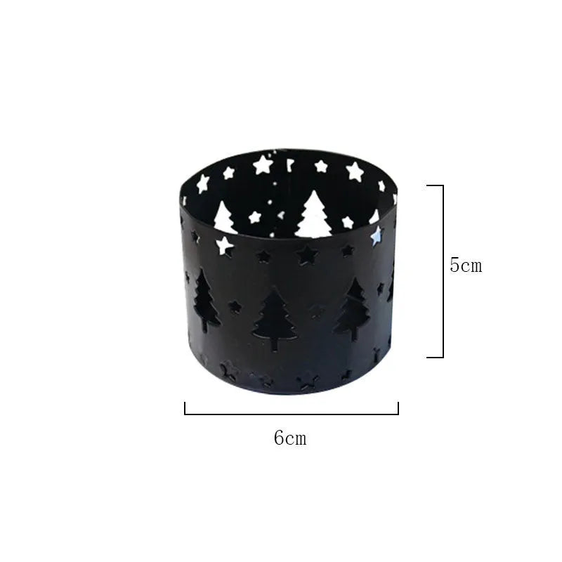Black iron Christmas candlestick holder with decorative elk design on a table.