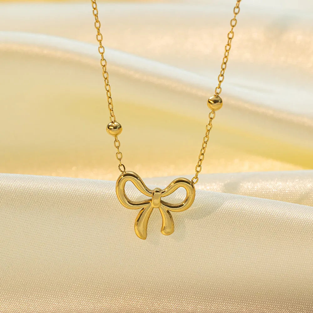 Gold bow necklace with cross chain links and adjustable 41-50cm length