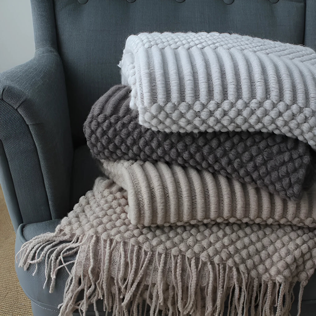 Small dark grey polyester nap blanket folded, showing its size of 127 cm by 170 cm.