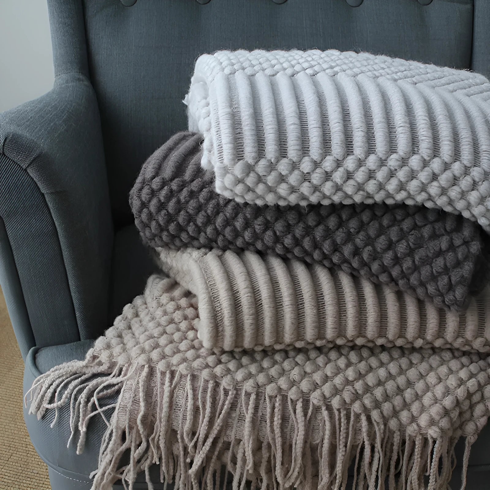 Small dark grey polyester nap blanket folded, showing its size of 127 cm by 170 cm.
